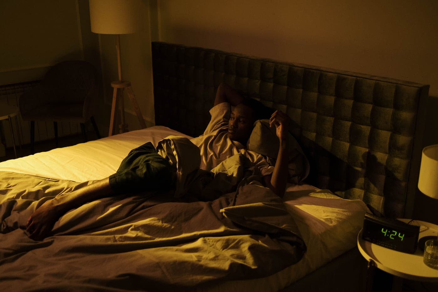 Person lying awake in a dark bedroom late at night