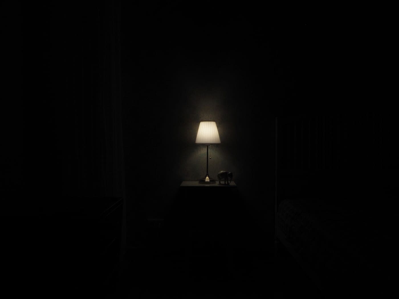 Small sound machine on a bedside table in a darkened room