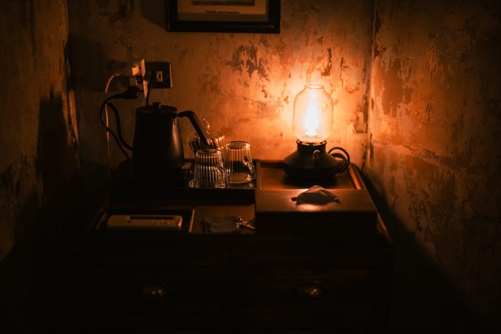 Warm-lit bedside table in a darkened room - illustrative category image