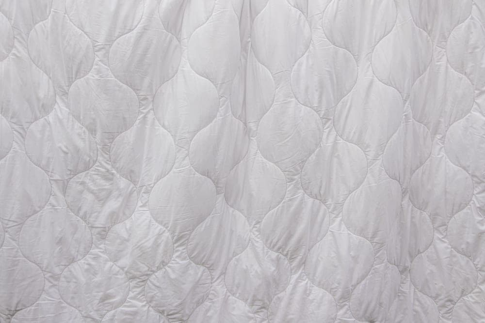 White quilted bedding photographed close up - illustrative category image